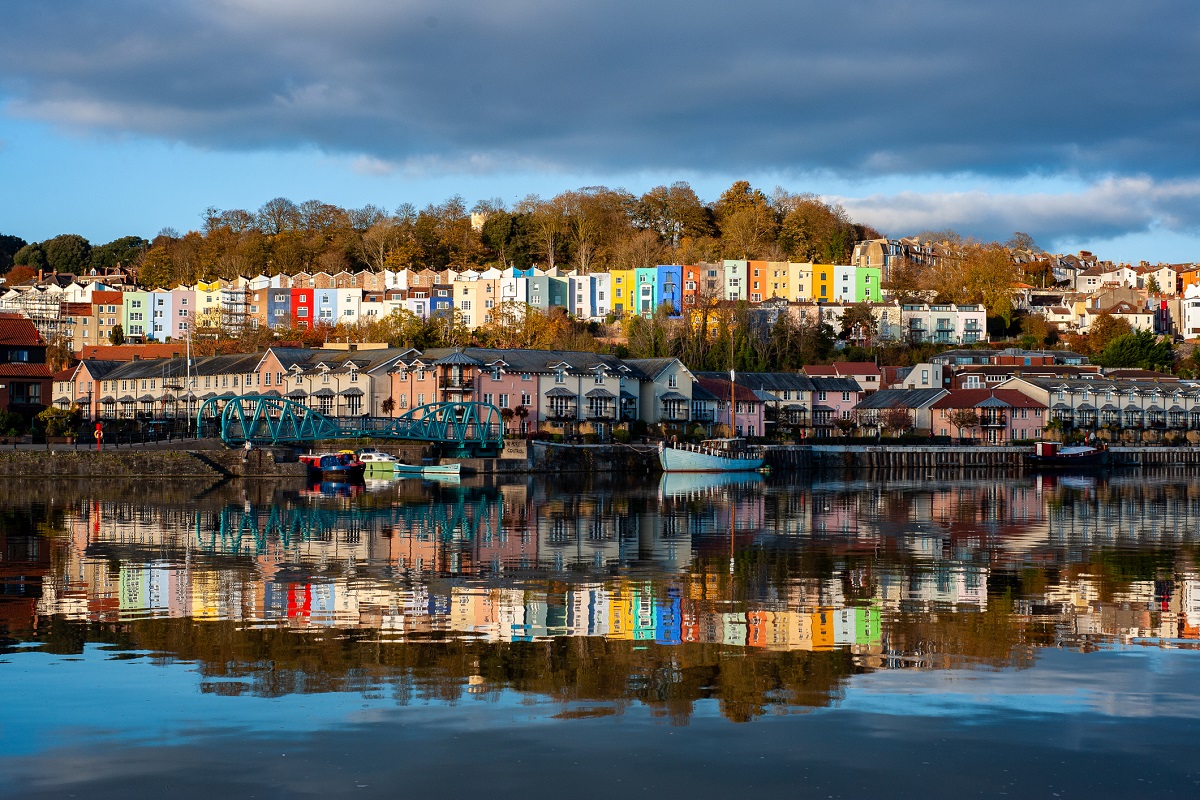 A mixture of modern and Georgian colourful houses reflected in the River Avon. Bristol harbourside, UK.