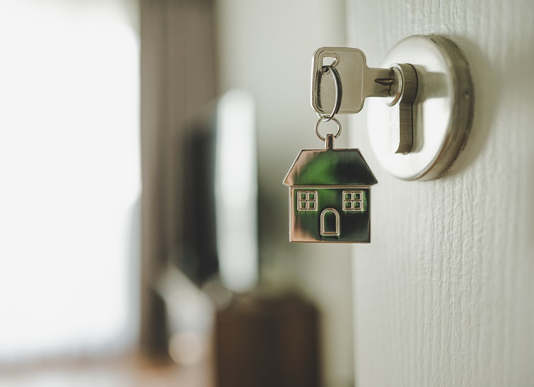 Door and door handle with a key and a keychain shaped house.