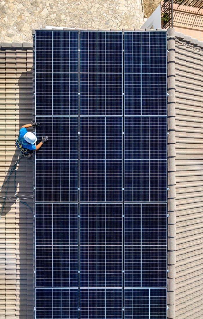 Solar panel installer installing solar panels with a big copy space
